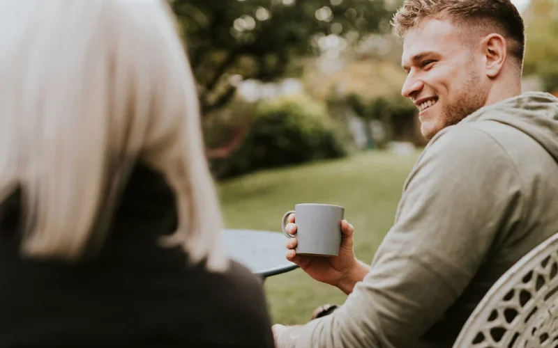 Man sitting with others with coffee in a garden
